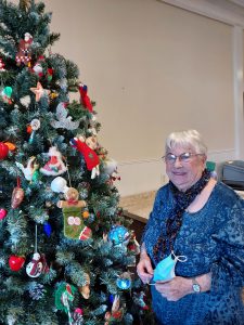 Lady in blue with decorated Christmas tree