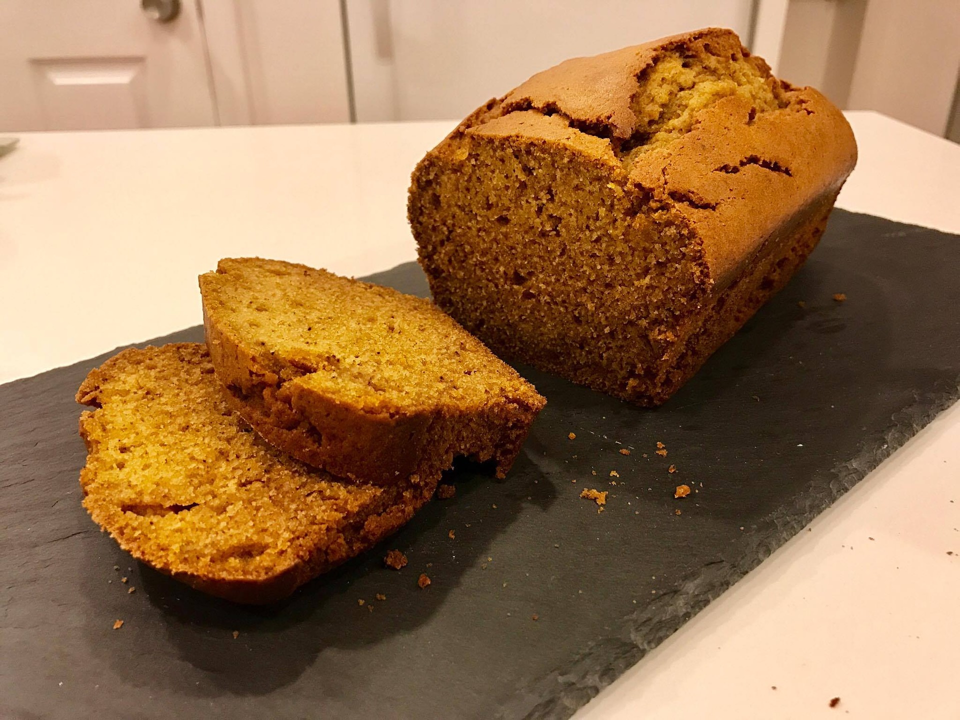 pumpkin-bread-loaf-sliced-on-dark-slate-board