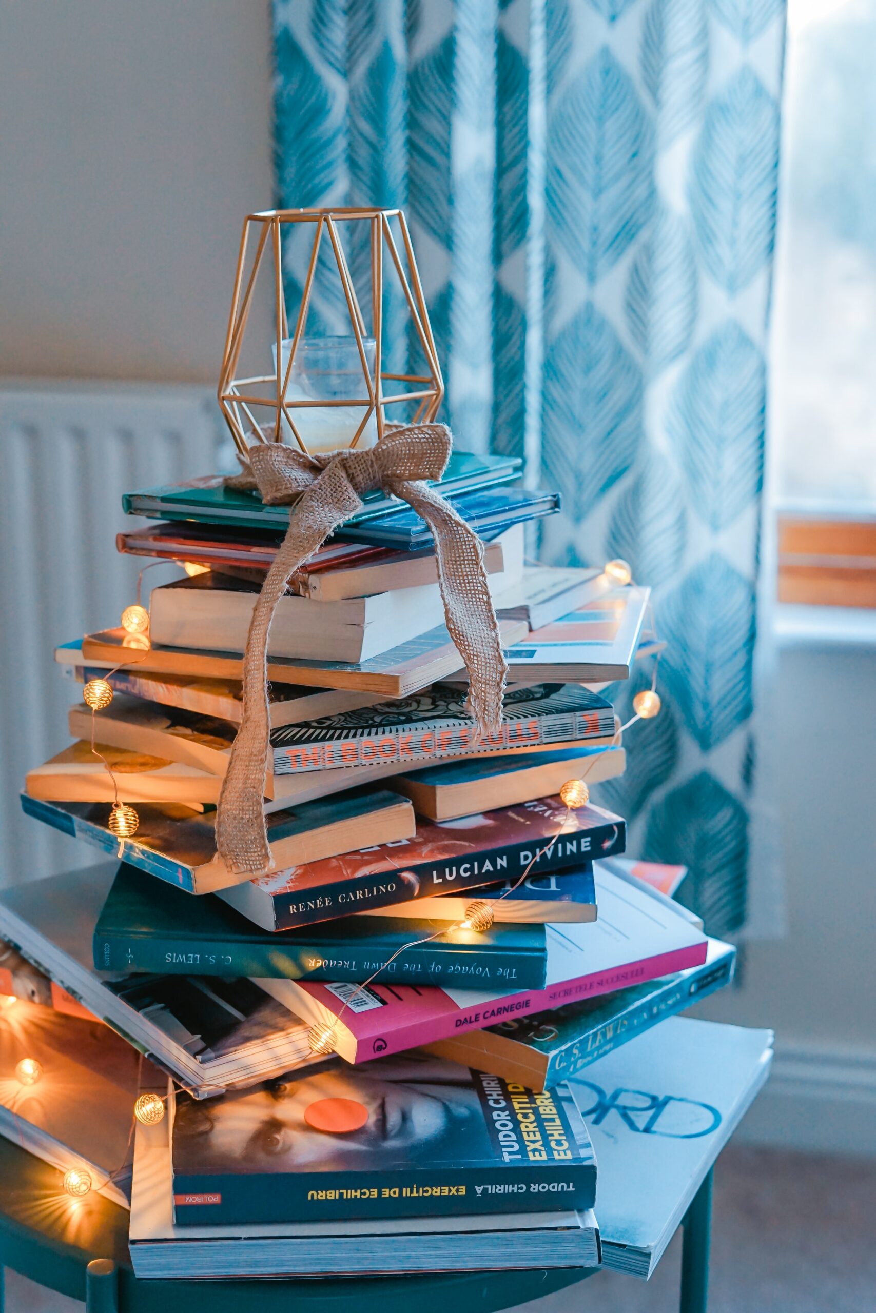 stack of books with ribbon bow and candle atop